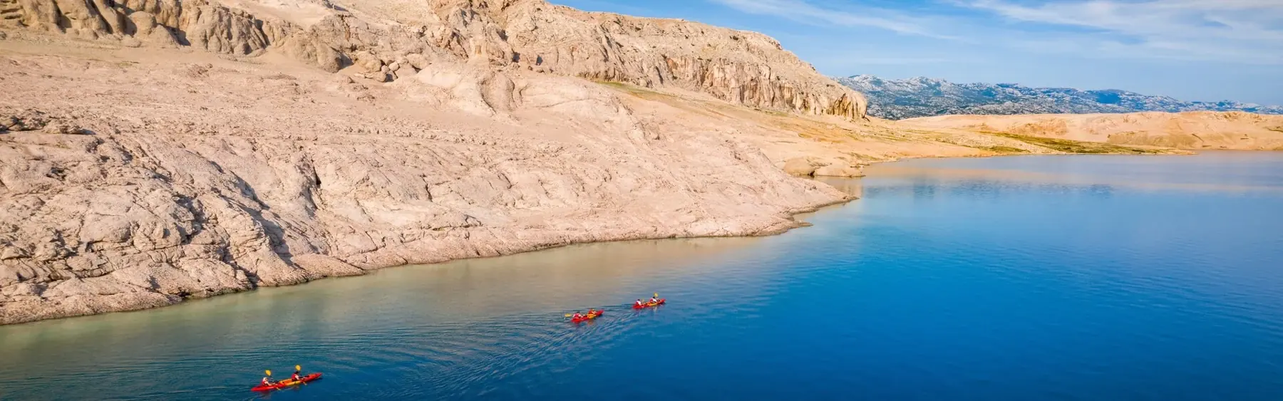 Blue Adriatic water and the pale rocky coastline of Pag
